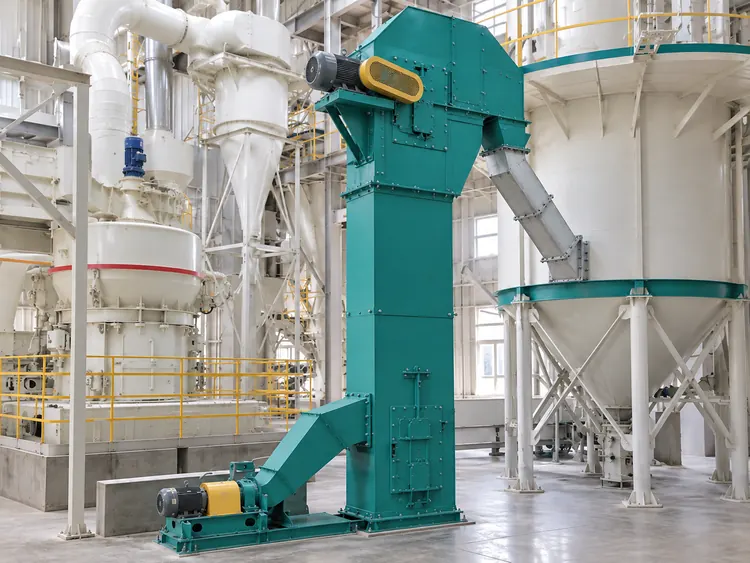 Turquoise bucket elevator with a lower screw feeder and discharge duct beside grinding equipment